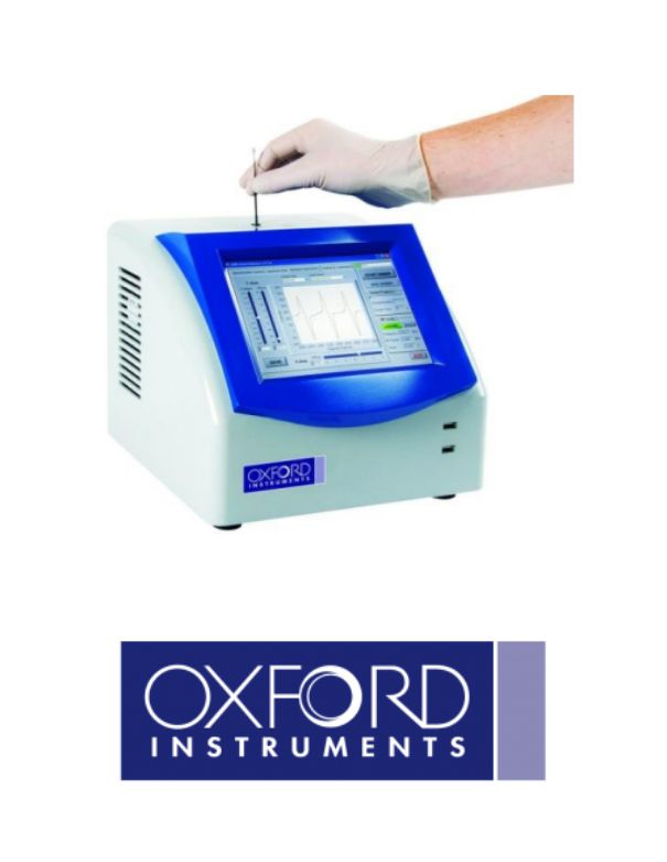 A hand wearing a glove is operating a laboratory instrument with a blue display screen, displaying data. Below the instrument is the logo for Oxford Instruments.