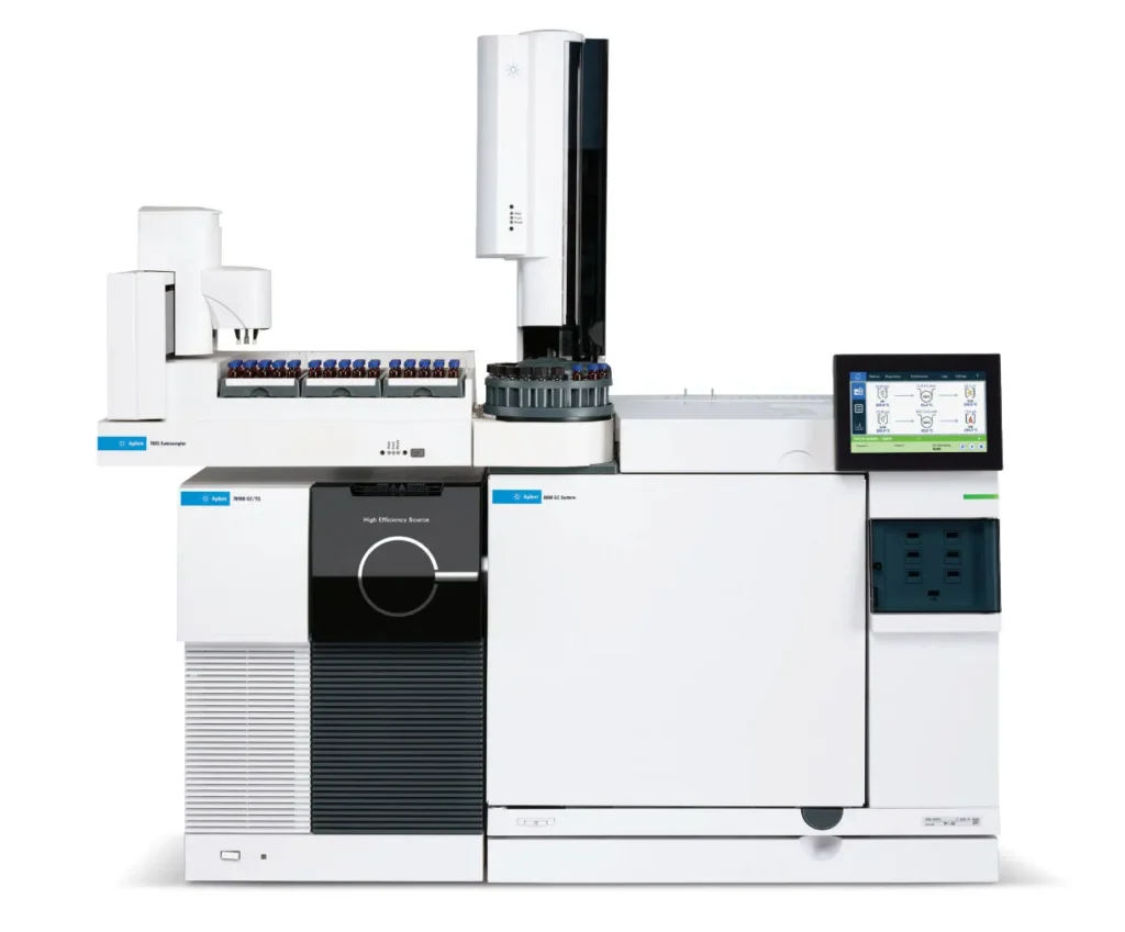 An advanced gas chromatography machine with a sleek white and black design. The device features a prominent display screen on the right, a control panel, and multiple compartments and sample vials on the left.